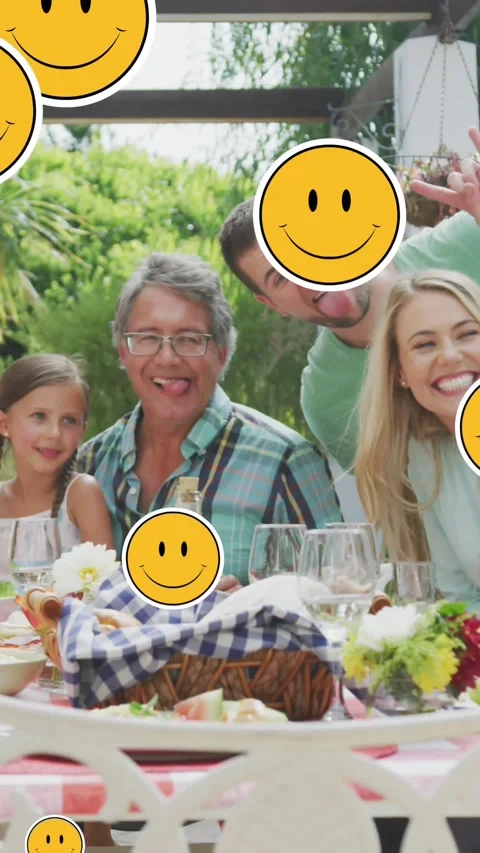 Animation of smiley faces over happy caucasian family taking selfie in garden Stock Footage 320759001