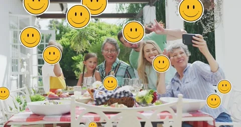 Animation of smiley faces over happy caucasian family taking selfie in garden Stock Footage 328225479