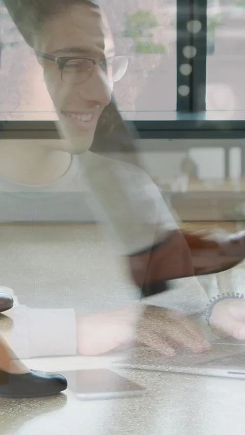 Animation of smiling woman using laptop at cafe over colleagues walking in Stock Footage 344693429