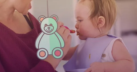 Animation of teddy bear icon over caucasian mother feeding her baby with spoon Stock Footage 328969492