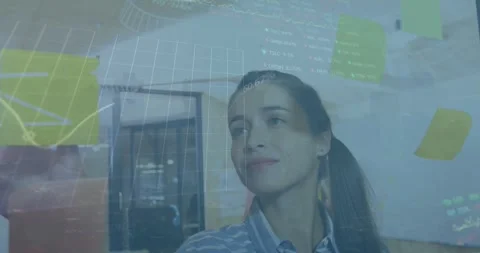 Animation of trading board and graphs over caucasian woman sticking notes on Video stock 328243938