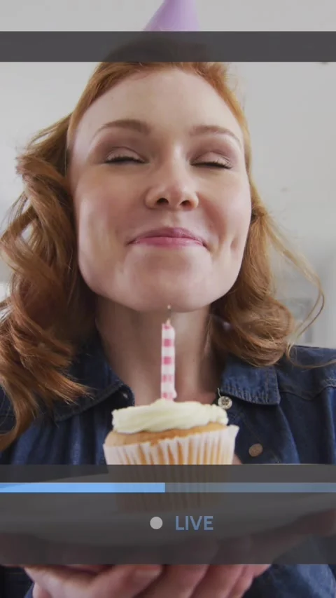 Animation of video screen over caucasian woman holding cupcake and blowing Stock-Footage 323899415