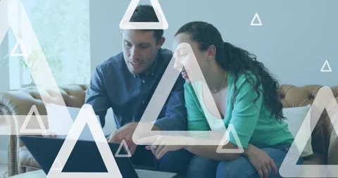 Animation of white triangles over caucasian couple using laptop Stock Footage 330175110