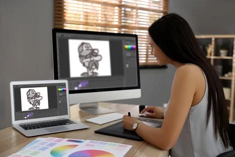 Animator working with graphic tablet, computer and laptop. Illustrations on.. Stock Photos