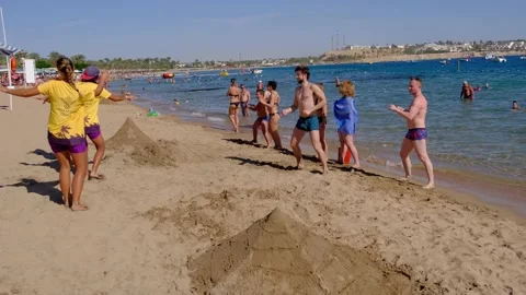 Animators on the beach dance and entertain vacationers. Video stock 169290688