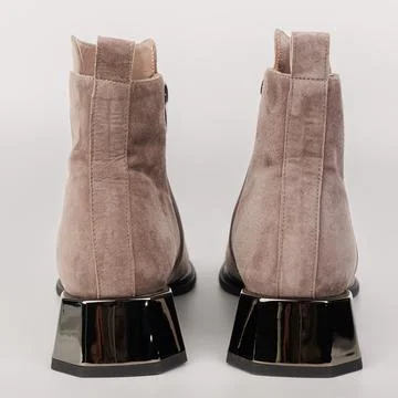 Ankle boots made of soft material are shown from the back. The boots have a s Stock Photos