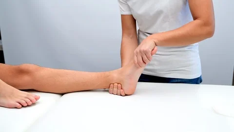 Ankle physiotherapy to a boy Stock Footage 98795501