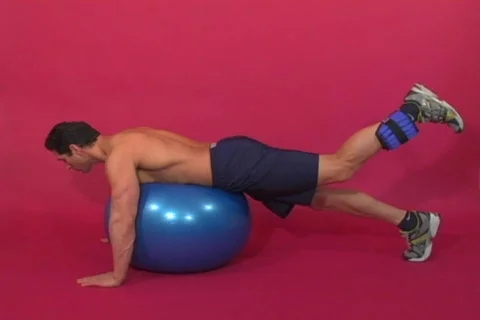 Ankle weights leg curl on stability ball Stock Footage 270412