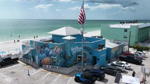 Anna Maria Island mural covers turquoise building beside crowded parking lot in Stock Footage 340191572