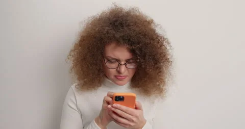 Anngry curly woman types text messages on smartphone quarrels with boyfriend on Stock Footage 151978005