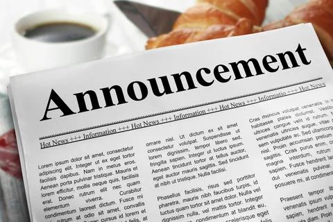 Announcement newspaper layout on a breakfast table with a blurry cup of cof.. Stock Photos
