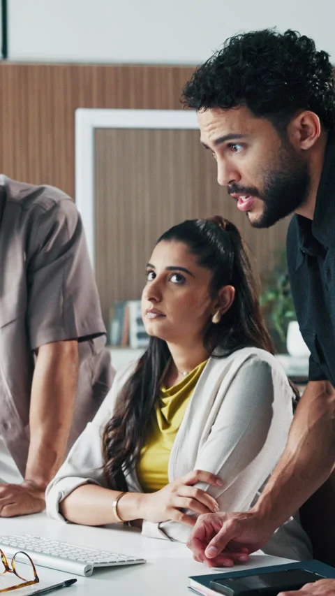 Annoyed, computer and talking with business people in office together for Stock Footage 331573464