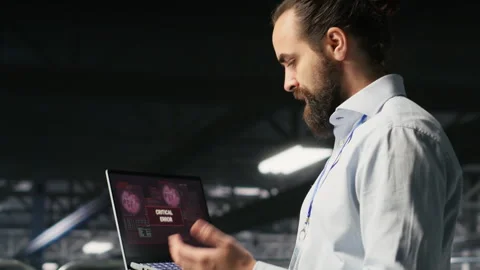 Annoyed engineer in data center reacting to critical error message on laptop Stock Footage 310276049