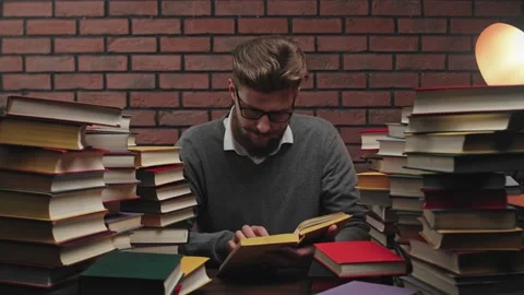 Annoyed Man Student Nervously Looking Through the Book. Man with Beard and Video stock 132668828