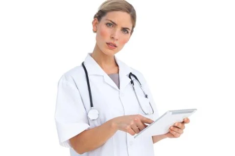 Annoyed nurse using tablet pc Stock Photos