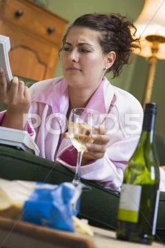 Annoyed young woman looking at telephone handset Stock Photos