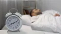 Annoying alarm sound waking up sleeping man in bed, rest deprivation, reminder 4k or 4k+ Resolution