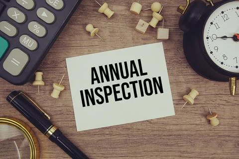 Annual Inspection text written on notepad with pen, alarm clock, magnifying.. Stock Photos