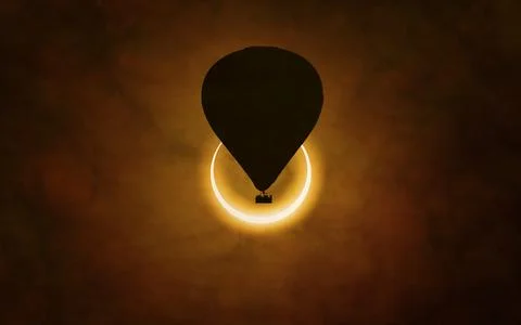 Annular solar eclipse in dark red sky. Hot air balloon rising high into sky Fotos Stock