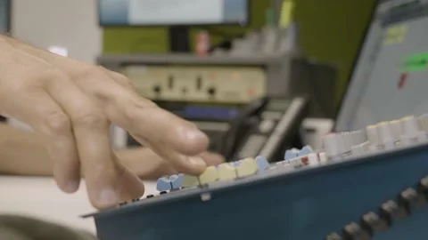 Anonymous audio engineer adjusting sound mixer knobs in recording studio, 動画素材 233986243