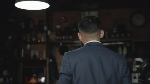 Anonymous barber walking in slow motion inside a barbershop Stock Footage 117693707