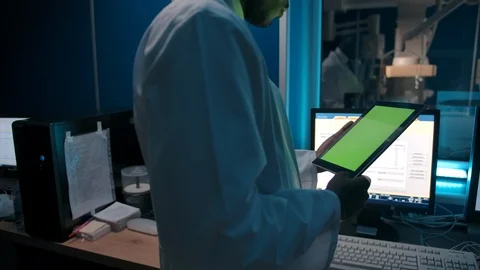 Anonymous black doctor reading data from tablet in lab Stock Footage 127198678