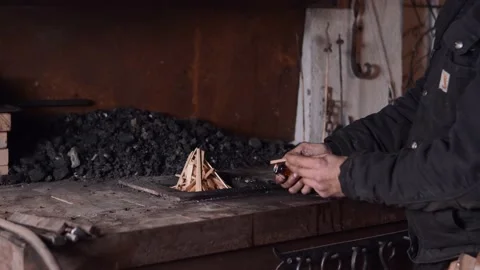 Anonymous blacksmith lighting fire in furnace Stock Footage 148128450