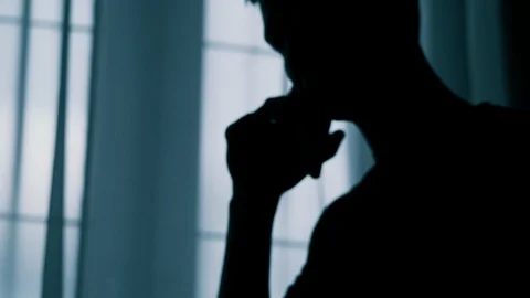 Anonymous blurred silhouette of a man talking on a cell phone, a criminal is Stock Footage