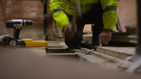 Anonymous builder hammering nails into flooring, in slow motion Stock Footage 111197181