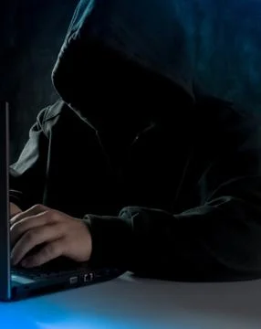 Anonymous computer hacker in hoodie. Using laptop computer for cyber attack. Foto stock