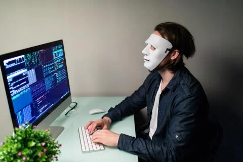 Anonymous computer hacker in white mask. Obscured dark face making silence ge Stock-Fotos