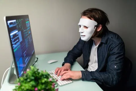 Anonymous computer hacker in white mask. Obscured dark face making silence ge Stock-Fotos