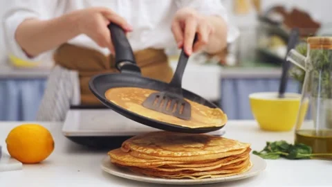 Anonymous cook putting a pancake on top of another pancake Video stock 168601445