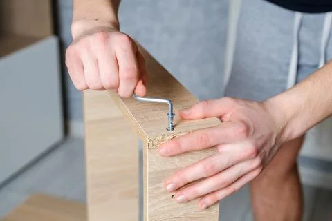 Anonymous craftsman using screwdriver for work with wooden furniture Stock Photos