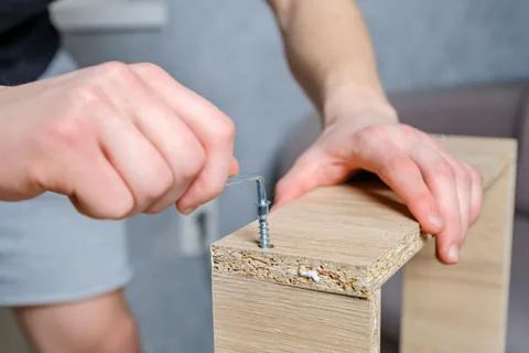 Anonymous craftsman using screwdriver for work with wooden furniture Stock Photos