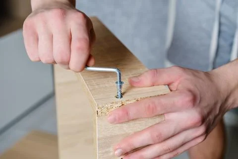 Anonymous craftsman using screwdriver for work with wooden furniture Stock Photos