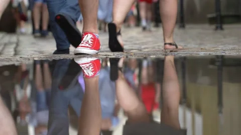 Anonymous Crowd Legs Walking on Cobblestone Street Reflected in Puddle 動画素材 165921469