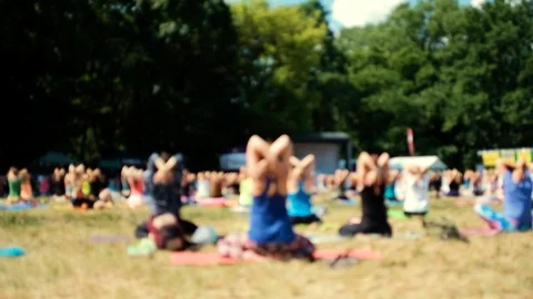 An anonymous crowd practices yoga in the park during a beautiful day Stock Footage 91095105