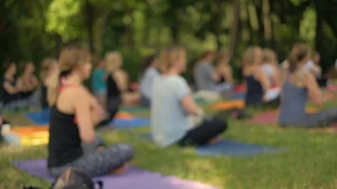 An anonymous crowd practices yoga in the park during a beautiful day Stock Footage 91095200