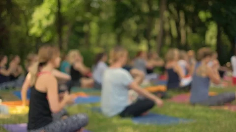 An anonymous crowd practices yoga in the park during a beautiful day Video stock 91095372
