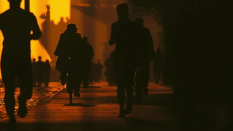 Anonymous crowd silhouettes walking in city underpass at sunset Stock Footage 330030128