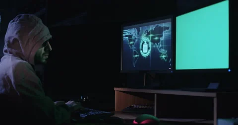 Anonymous cyber terrorist sitting in a dark room in front of screens  Stock Footage 68293867