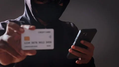 Anonymous cybercriminal using a smartphone and credit Stock Footage 337392649