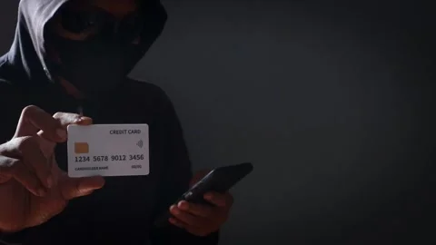 Anonymous cybercriminal using a smartphone and credit Stock Footage 337392682