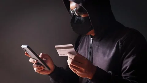 Anonymous cybercriminal using a smartphone and credit Stock Footage 337392687