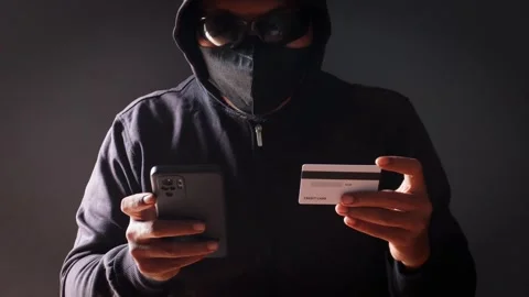 Anonymous cybercriminal using a smartphone and credit Vidéo 337392690
