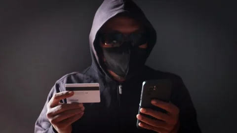 Anonymous cybercriminal using a smartphone and credit Stock Footage 337392749