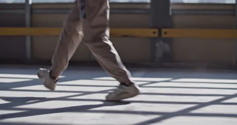 Anonymous dancer walking on sunlit floor Stock Footage 213643248