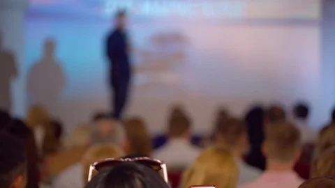Anonymous defocused of speaker. Listening to the speech about marketing and Stock Footage 94838596