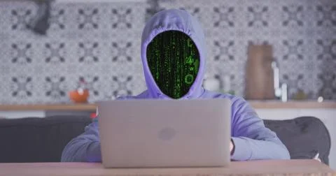 Anonymous faceless man works behind laptop. Matrix effect instead of hooded face Foto stock